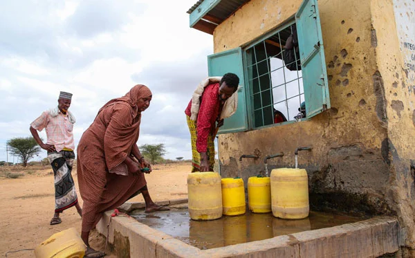 People in Kenya taking water from water kiosk
